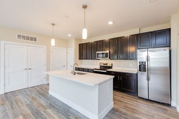 A kitchen with stainless steel appliances and black cabinets